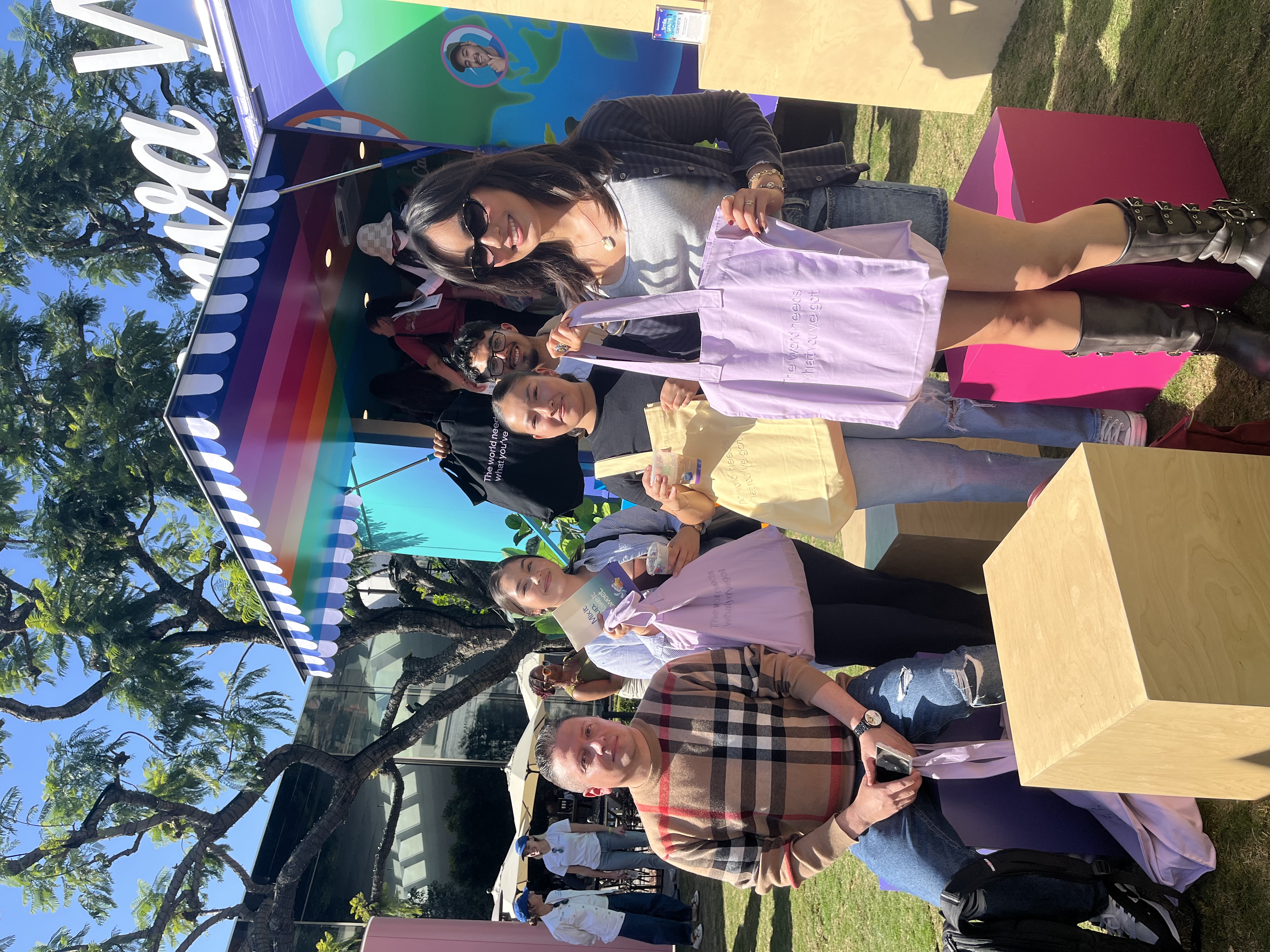 LSBA members holding tote bags at an outdoor Buena Vibra brand activation on a sunny day.